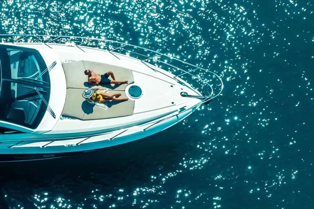 aerial-view-couple-enjoying-sunbathing-luxury-yacht-moving-sea