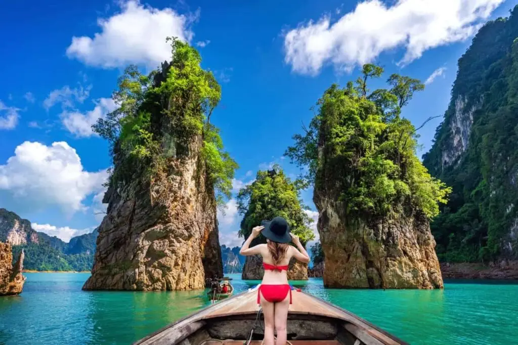 beautiful-girl-standing-boat-looking-mountains-ratchaprapha-dam-khao-sok-national-park-surat-thani-province-thailand