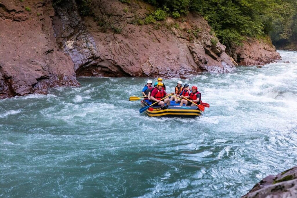 group-happy-people-with-guide-whitewater-rafting-rowing-river