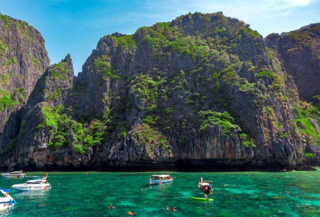 yacht-sailing-sea-kayaking-by-rocky-mountain-against-sky-phang-nga-bay-phi-phi-islands